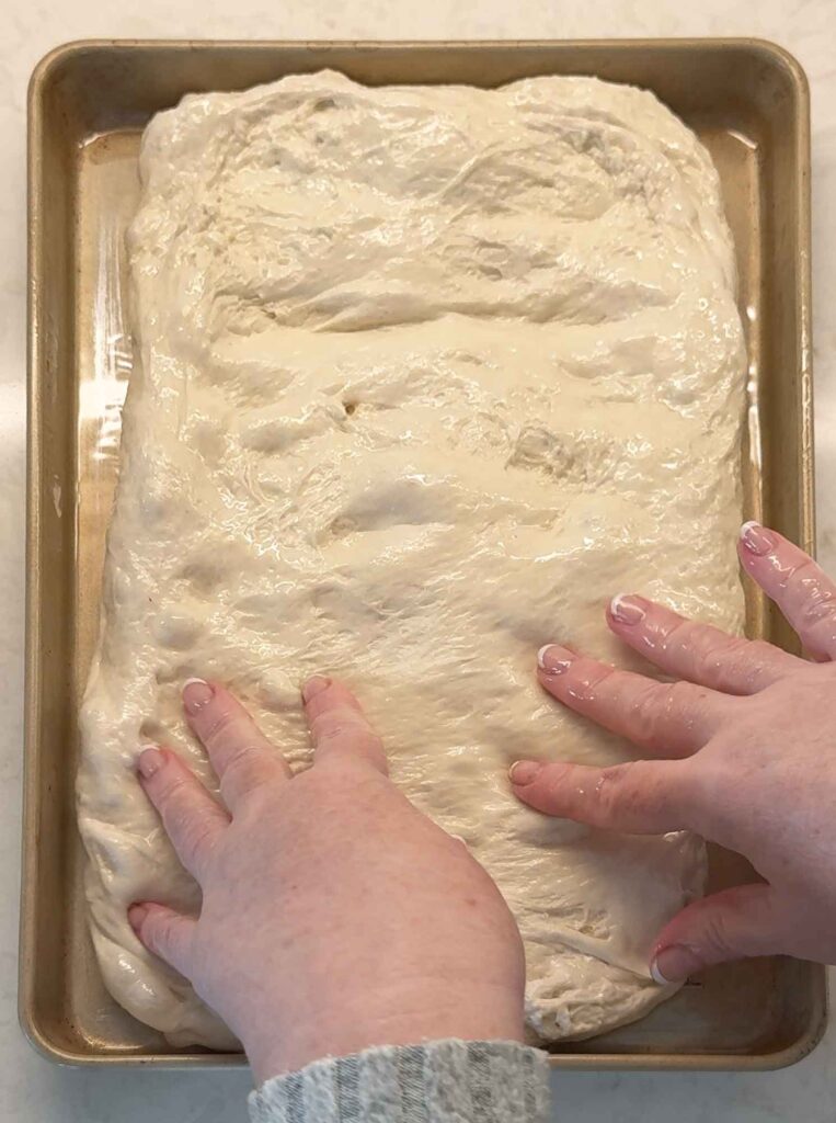 Spreading sourdough in oiled pan