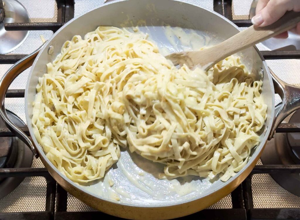 Tossing the fettucine alfredo in the skillet