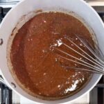 mixing sauce ingredients in the sauce pan with a whisk