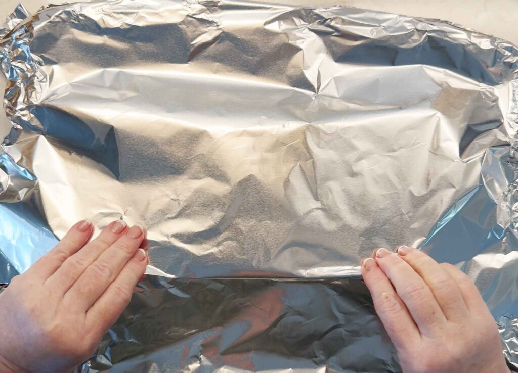 Wrapping the ribs tightly in foil, crimping the edge