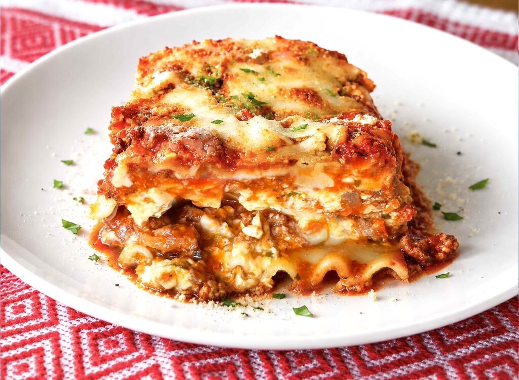 A plated slice of easy lasagna showing the layers of noodles, cheese, and meat sauce.