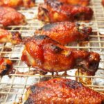 Sauced BBQ chicken wings back on the rack, glazed with barbecue sauce and broiled