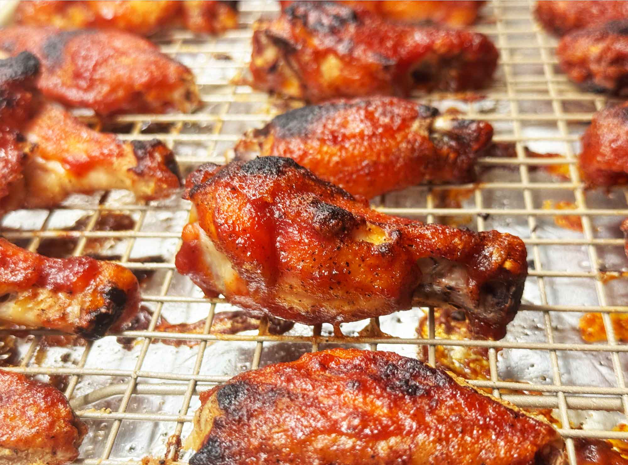 Sauced BBQ chicken wings back on the rack, glazed with barbecue sauce and broiled