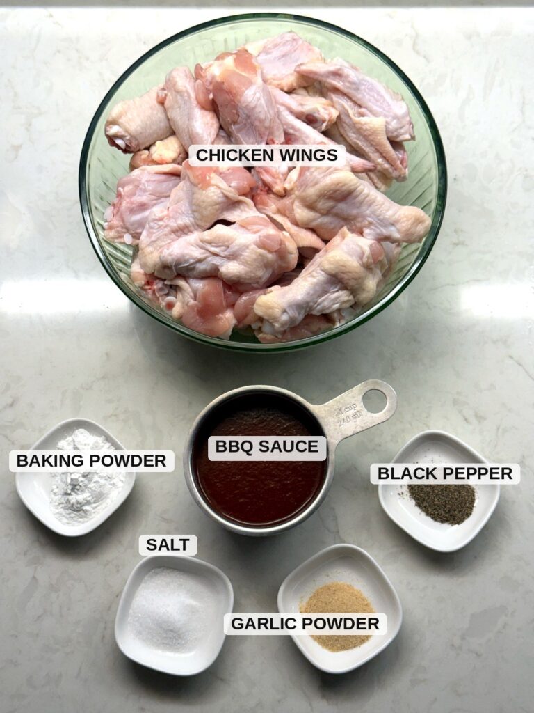 Labeled ingredients for baked BBQ chicken wings: chicken wings, baking powder, BBQ sauce, salt, black pepper, and garlic powder