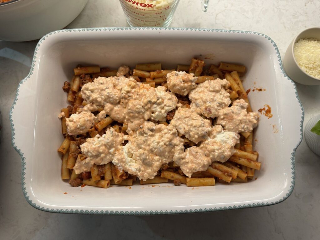 Dollops of the creamy cheese layer spread over the first layer of saucy ziti
