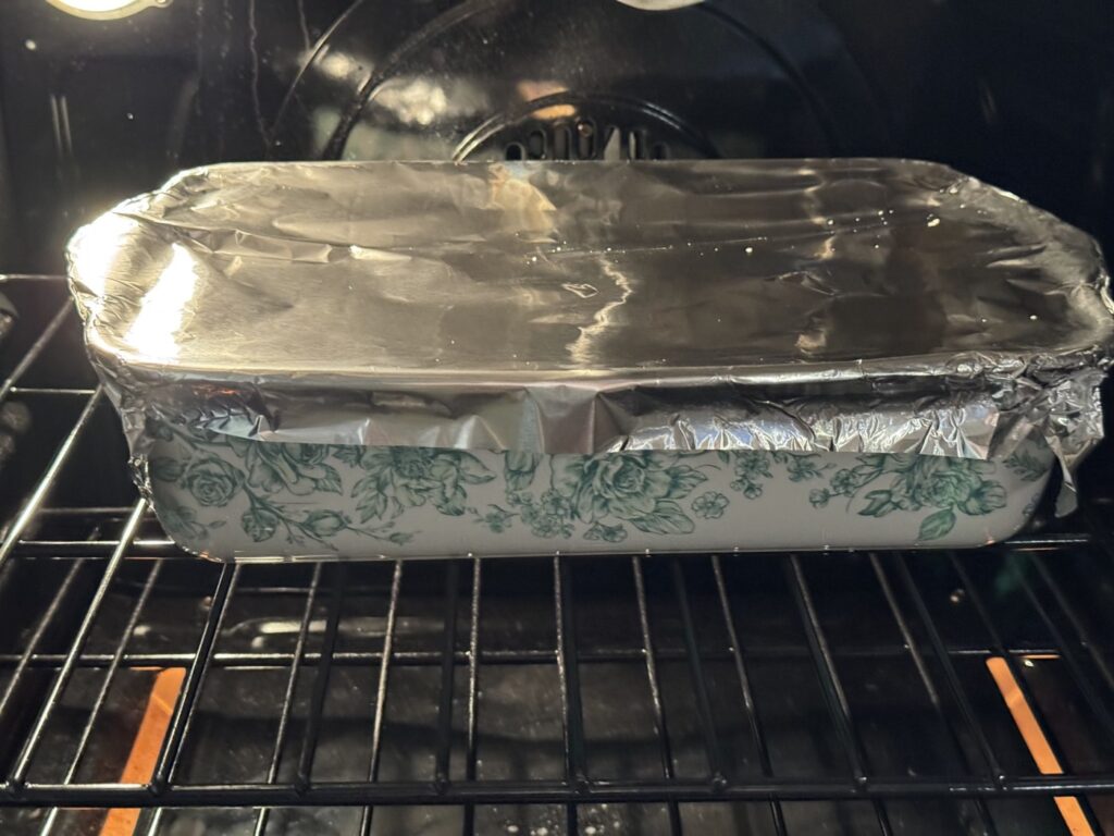 Baked ziti covered with foil baking on the oven rack