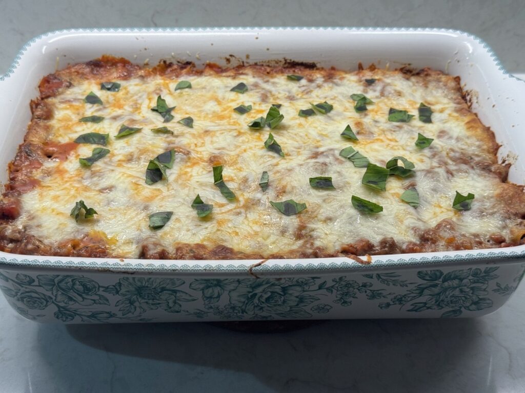 Finished baked ziti topped with fresh torn basil
