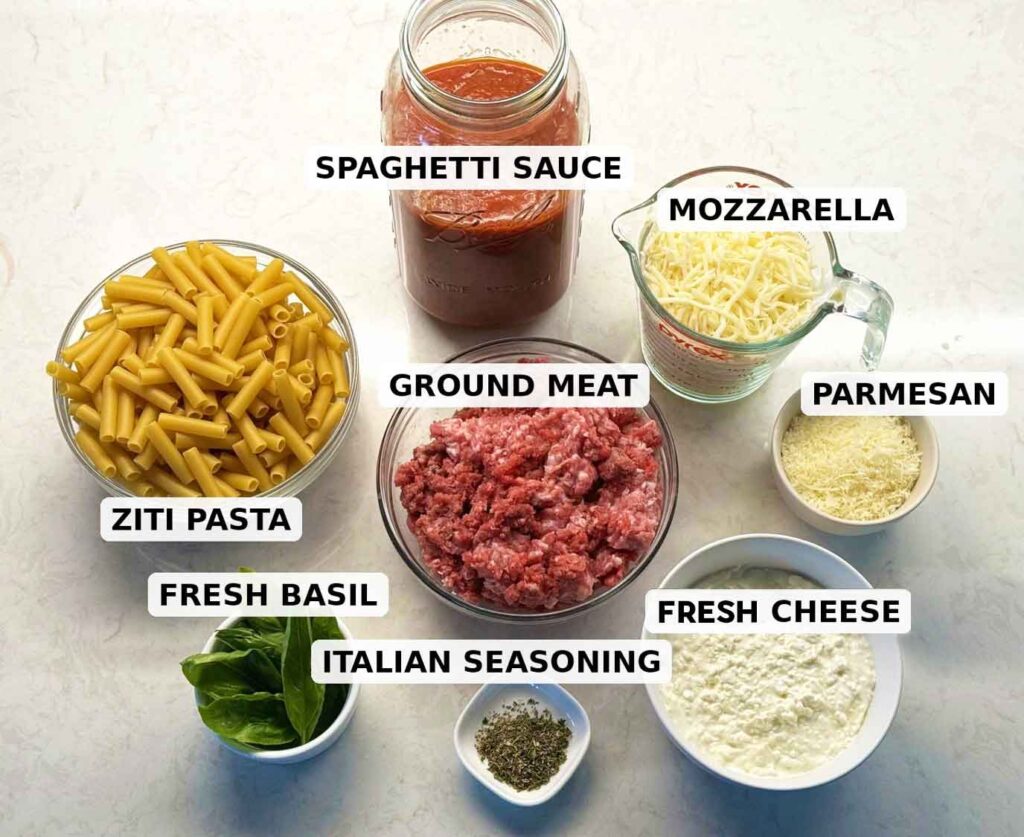 Labeled baked ziti ingredients: ziti pasta, ground beef and pork, spaghetti sauce, fresh cheese, mozzarella, Parmesan, Italian seasoning, and fresh basil