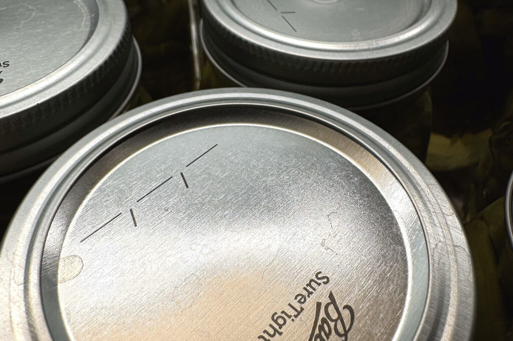 Close-up of a sealed canning lid curved slightly downward in the center