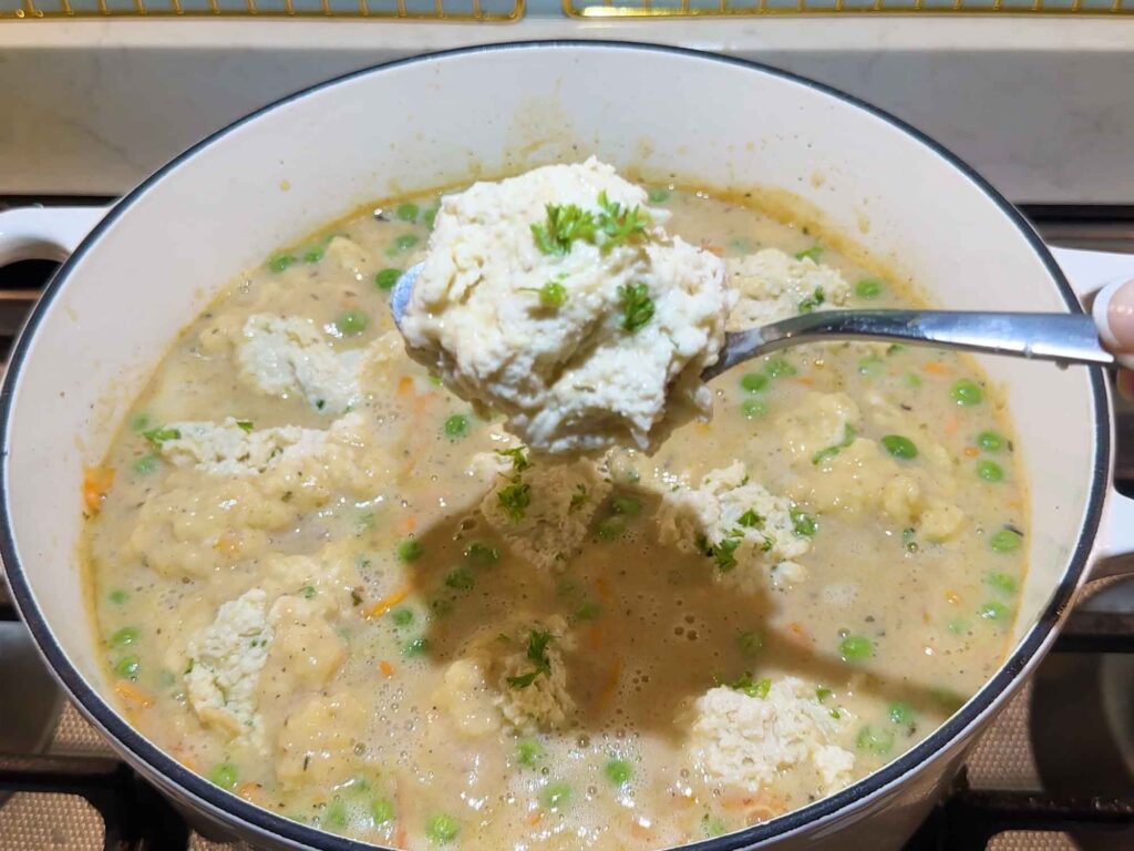 Dropping spoonfuls of dumplings into the stew
