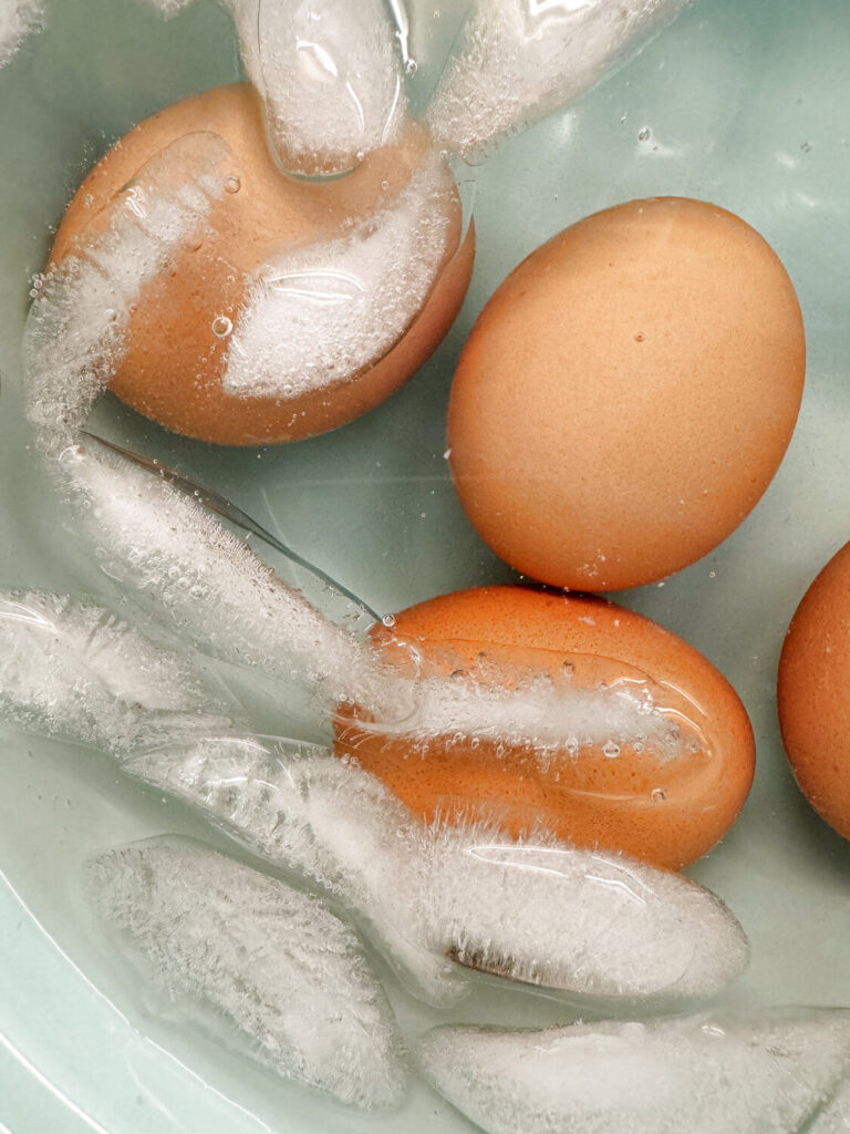 Hard-boiled eggs cooling in a bowl of ice water