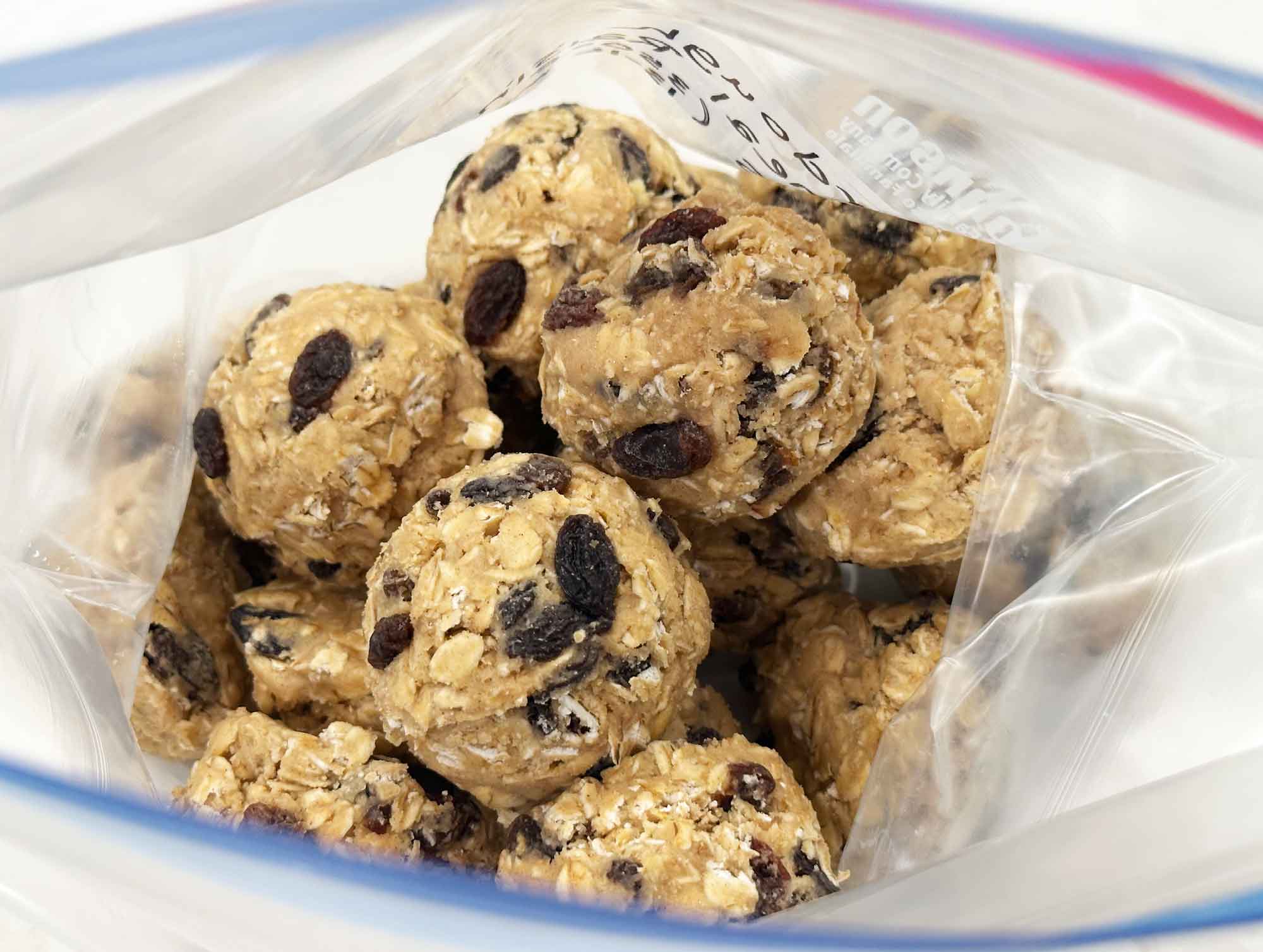 Frozen sourdough oatmeal cookie dough balls stored in a labeled freezer bag.