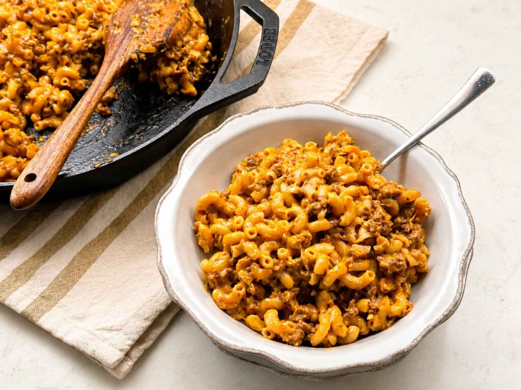 Homemade hamburger helper in a bowl near a skillet