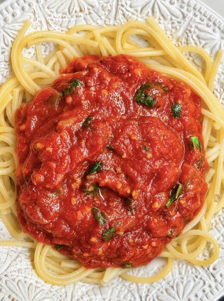 Homestyle tomato basil spaghetti sauce over pasta in a bowl