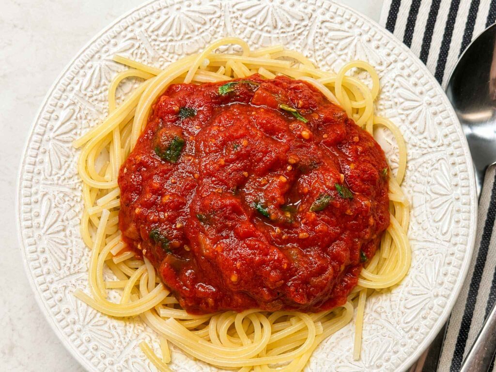 Homestyle tomato basil spaghetti sauce over pasta in a bowl