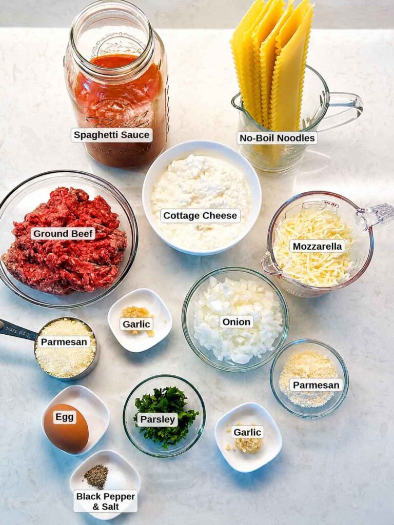 Lasagna ingredients: jarred sauce, dry no-boil noodles, ground beef, cottage cheese, mozzarella, parmesan, egg, garlic, and parsley.