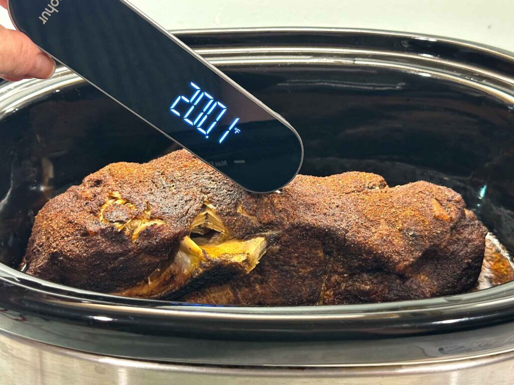 An instant read thermometer in the thickest part of the pork shoulder reading 200.1 F.