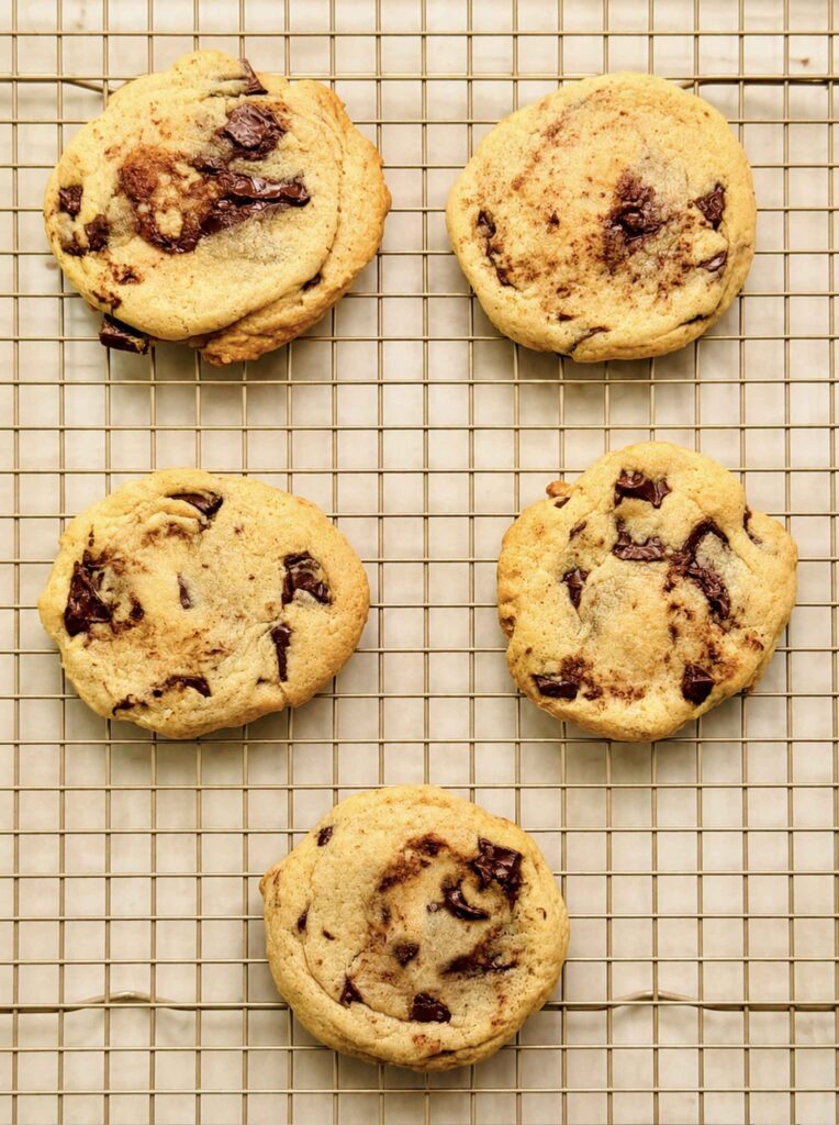Soft, thick sourdough chocolate chip cookies cooling on a wire rack.