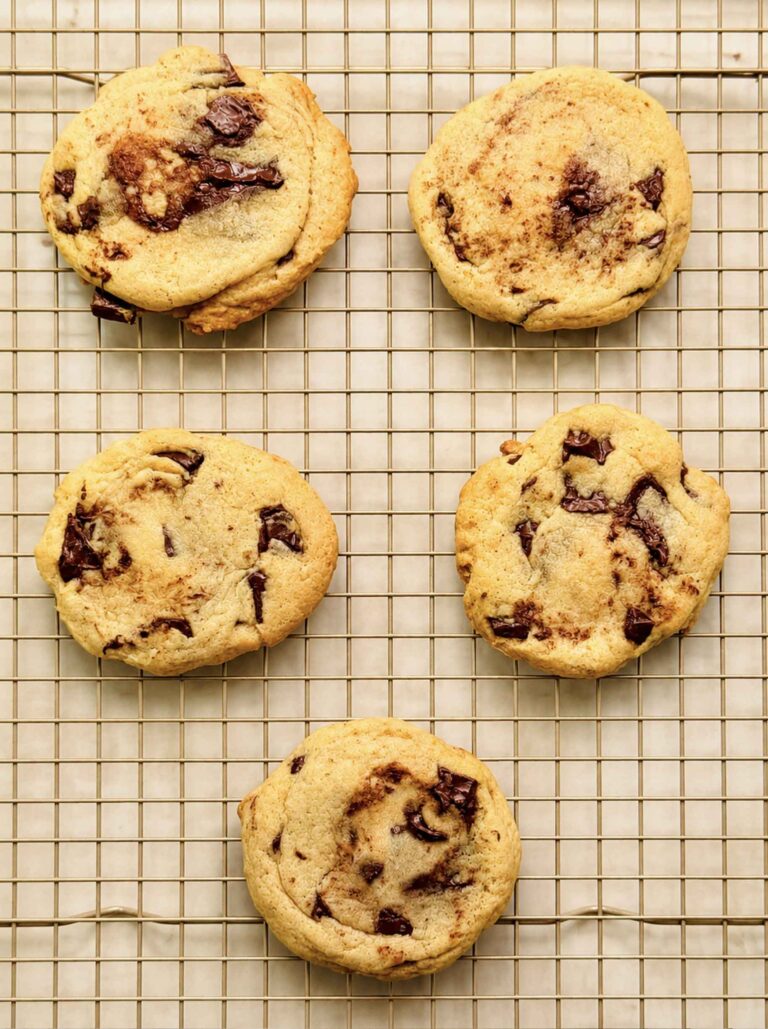 Soft, thick sourdough chocolate chip cookies cooling on a wire rack.