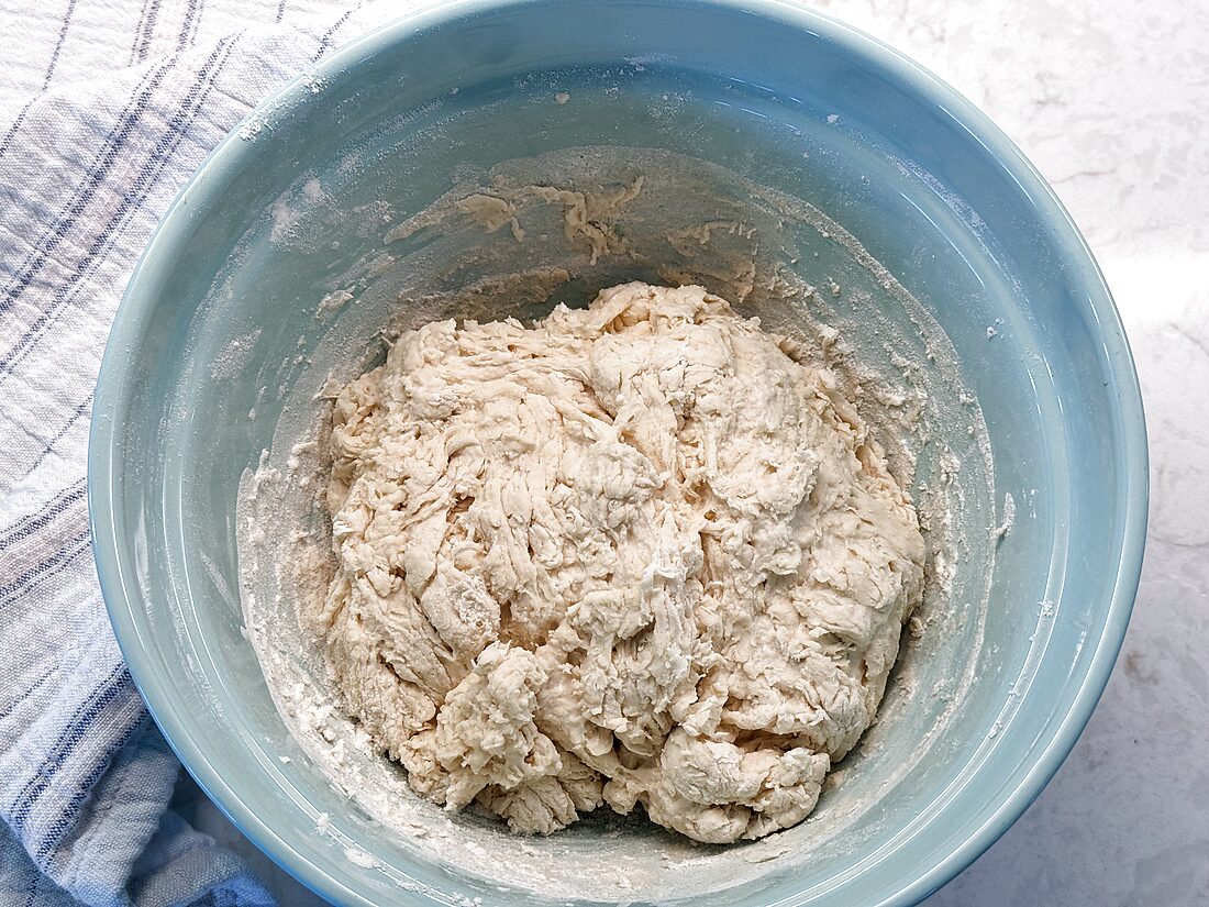 Shaggy, rough sourdough pizza dough in a bowl right after mixing the flour and water