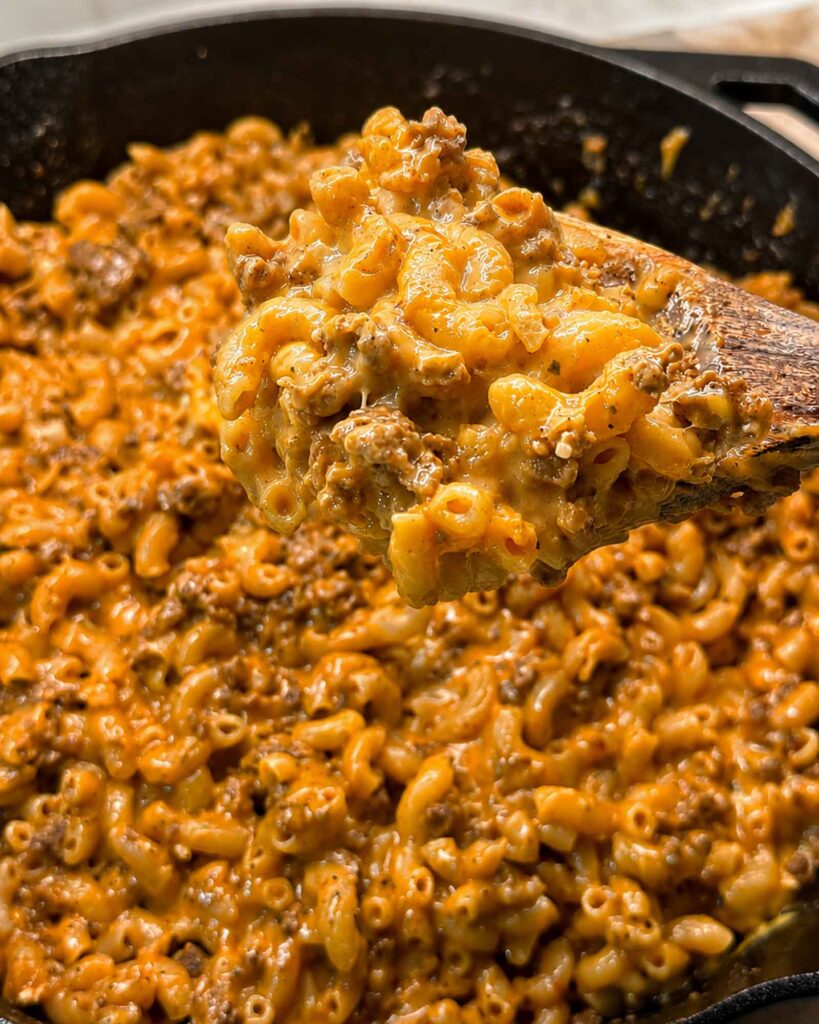 A heaping spoon of homemade hamburger helper from a skillet