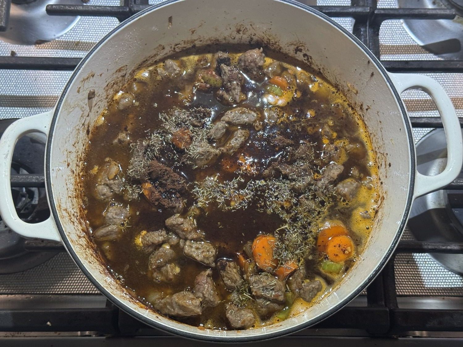 Beef and vegetables simmering in gravy in the pot