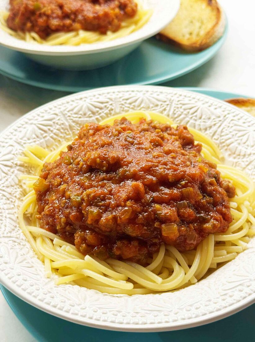 Home-canned spaghetti sauce with meat served over spaghetti with garlic bread on the side
