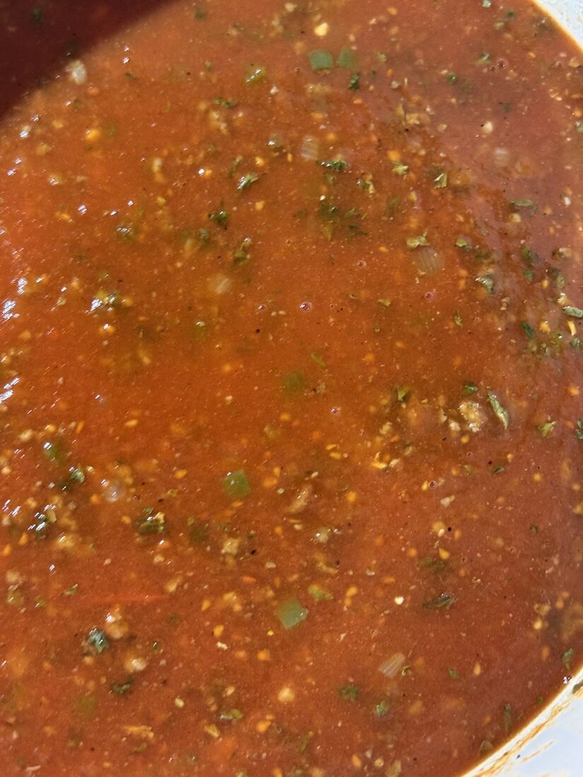 Close-up of the seasoned meat sauce simmering and reducing in the pot