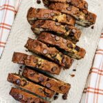 Overhead view of chocolate chip banana bread cut into thick slices on a white platter