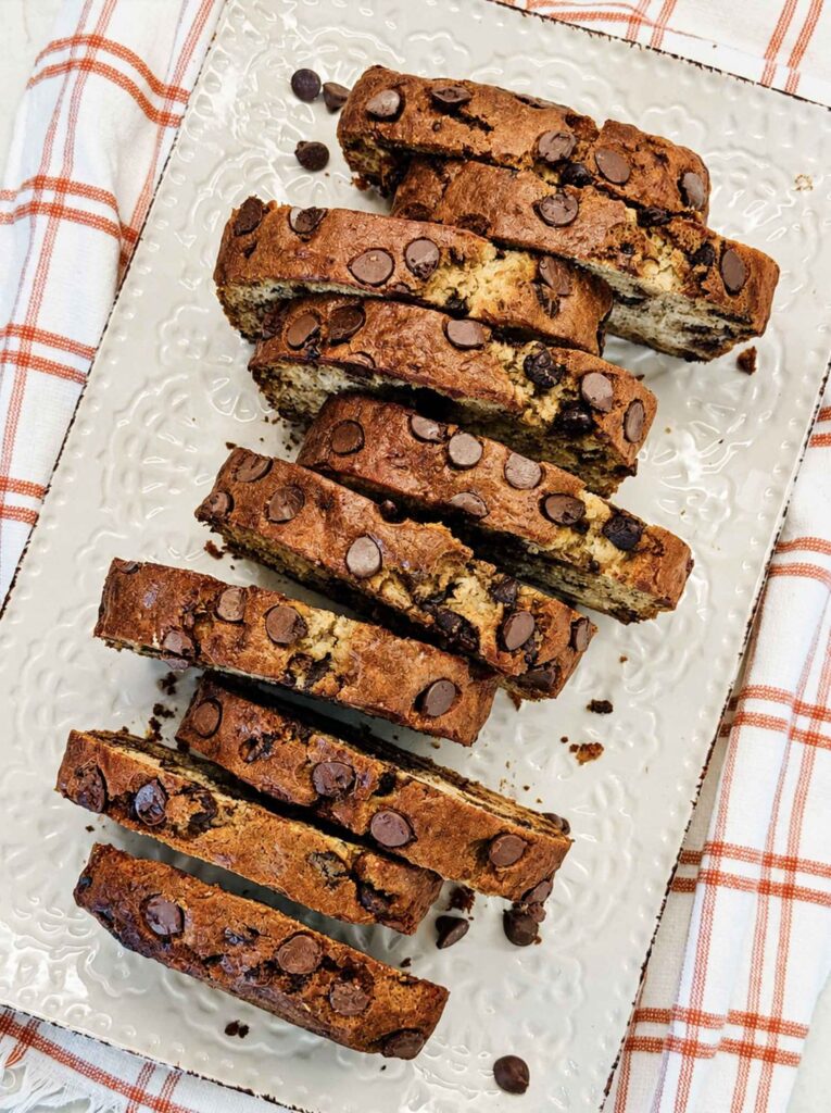 Overhead view of chocolate chip banana bread cut into thick slices on a white platter