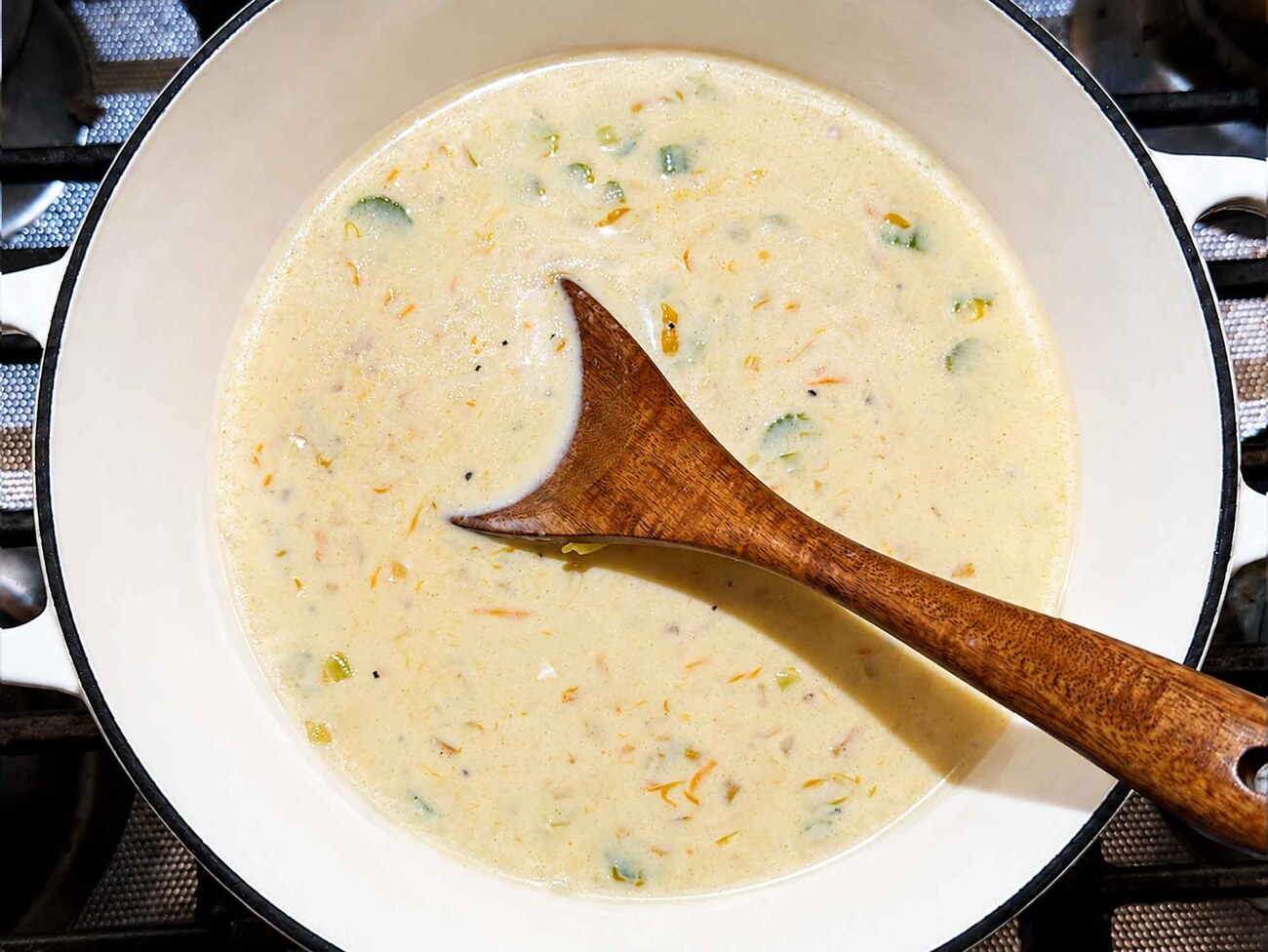 Creamy homemade sauce with a wooden spoon in the pot