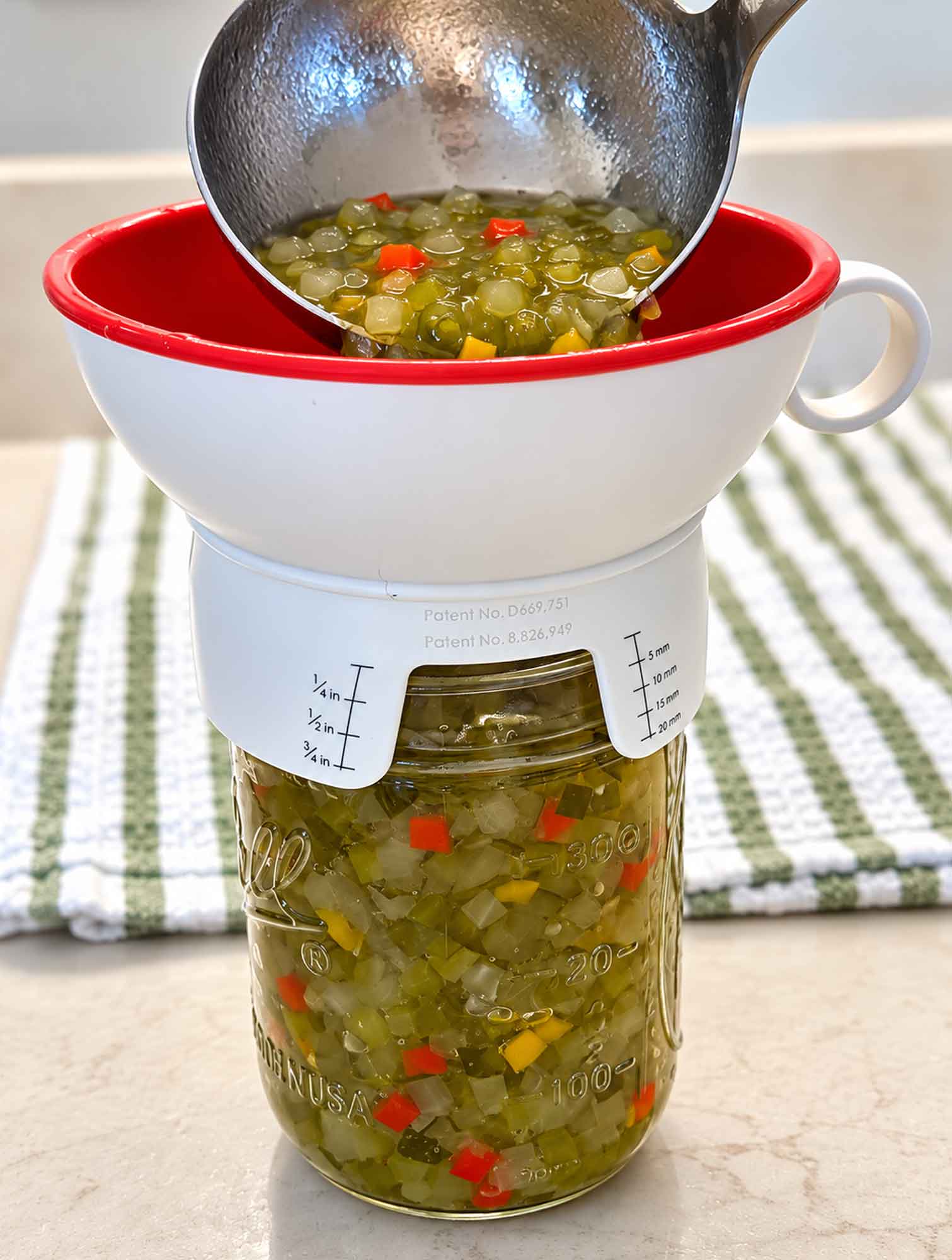 Filling a half-pint jar with hot sweet pickle relish through a canning funnel