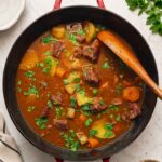 Rich beef stew with chunks of carrots, potatoes, peas, and braised beef in a rich gravy