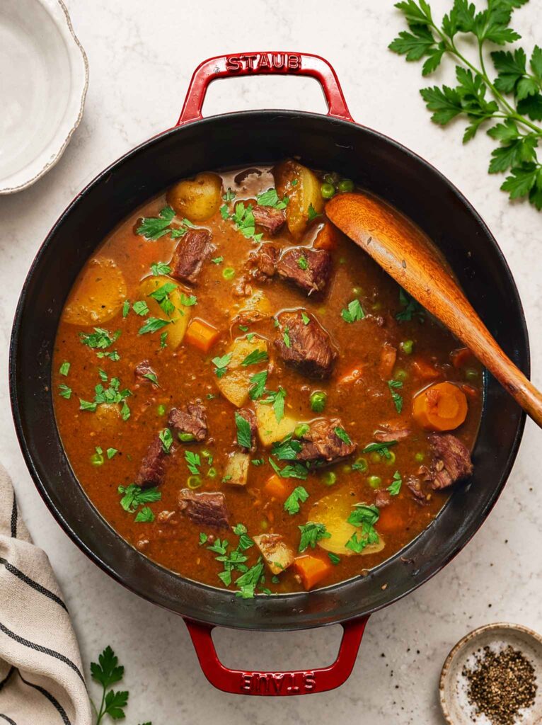 Rich beef stew with chunks of carrots, potatoes, peas, and braised beef in a rich gravy