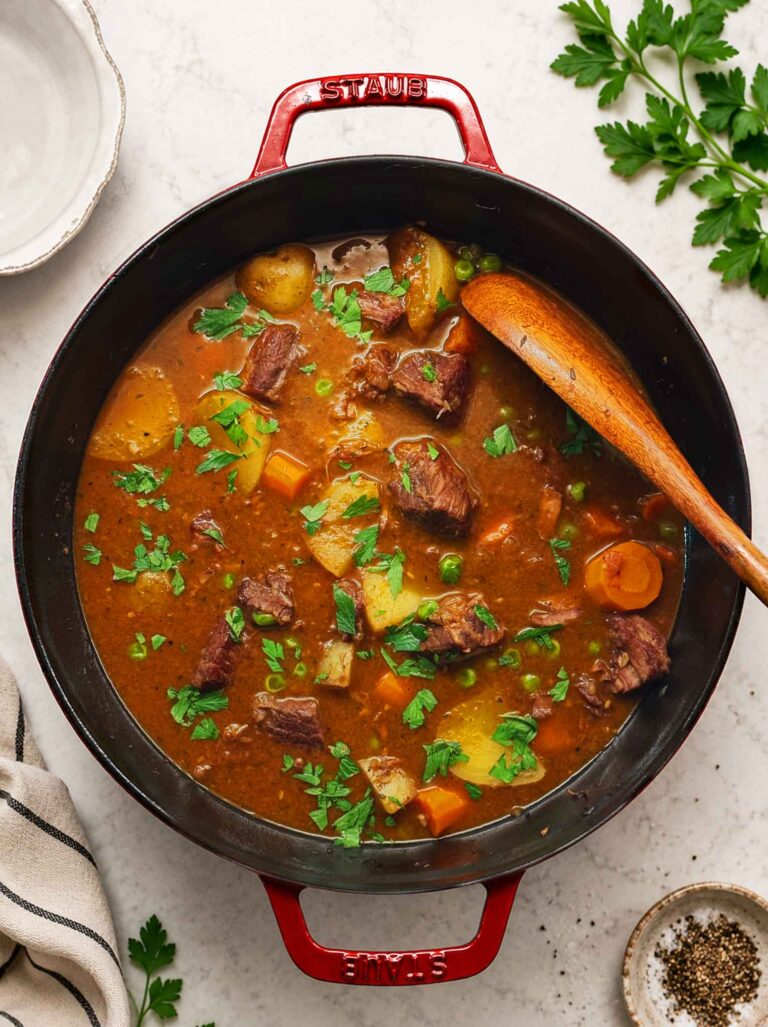Rich beef stew with chunks of carrots, potatoes, peas, and braised beef in a rich gravy
