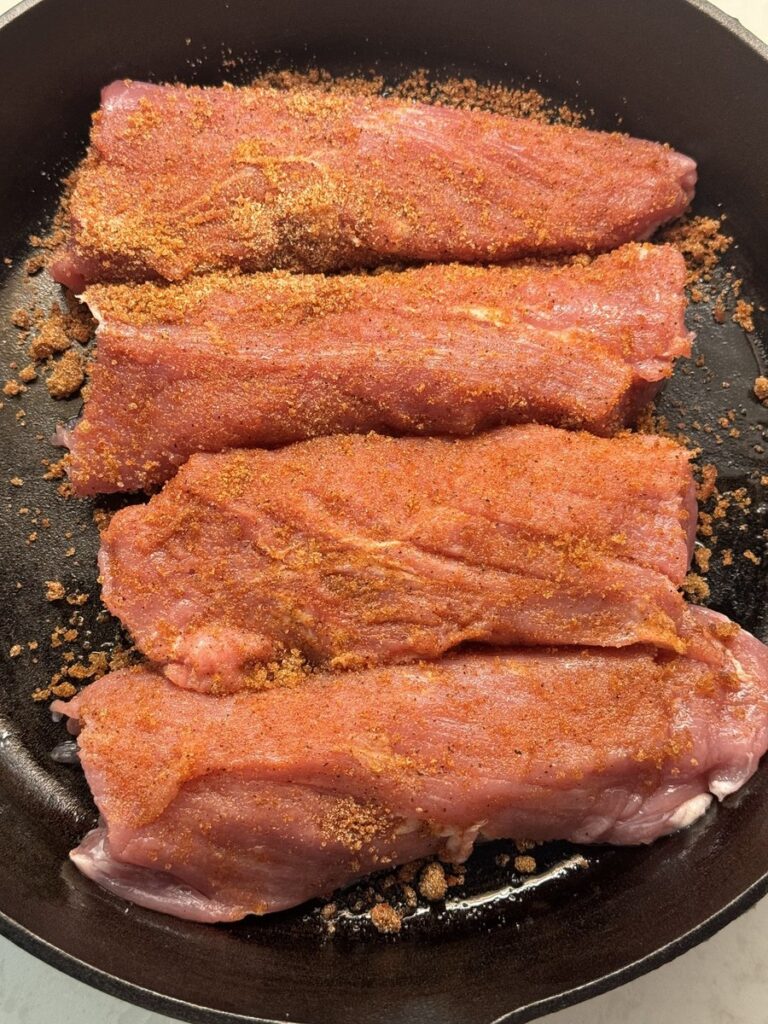 Pork tenderloin coated in a brown sugar garlic rub in the skillet