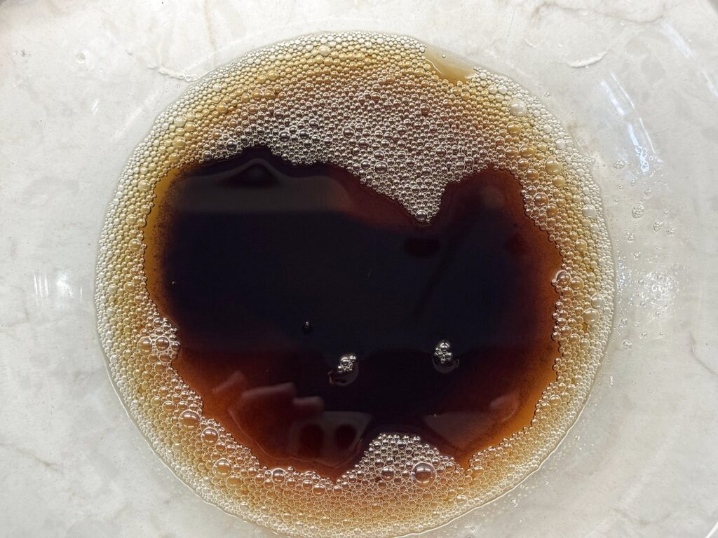 Deep amber browned butter with a ring of foam in a glass mixing bowl