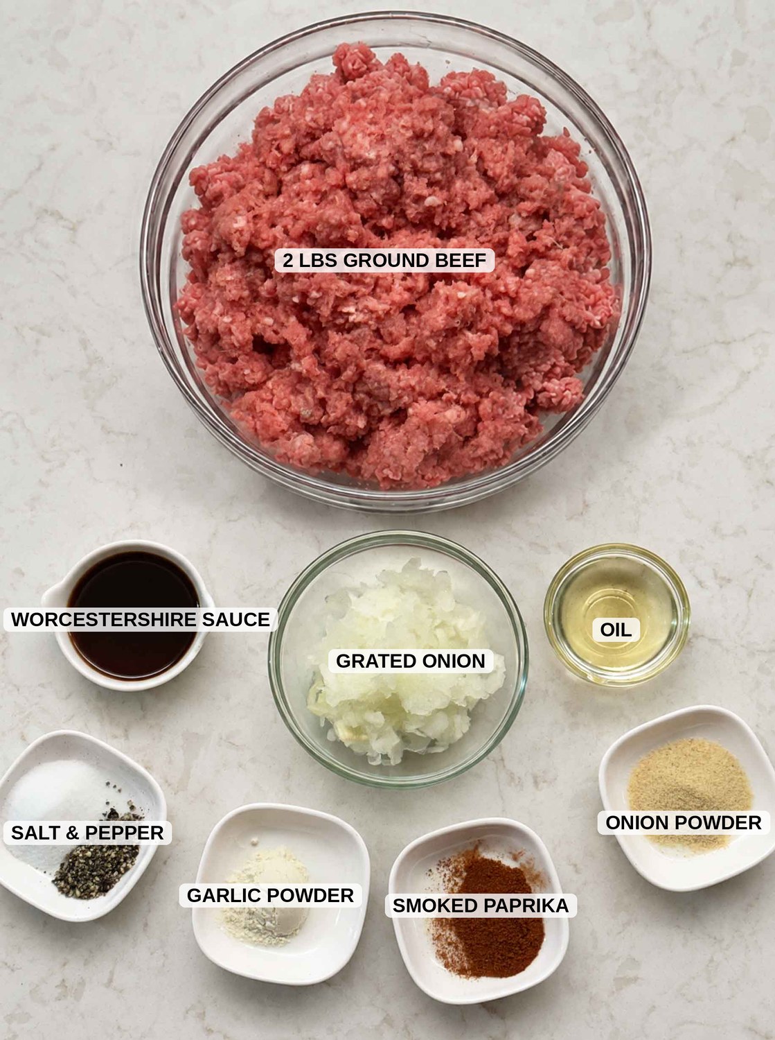 Labeled ingredients for this burger patty recipe: 2 pounds ground beef, grated onion, Worcestershire sauce, oil, salt and pepper, garlic powder, onion powder, and smoked paprika