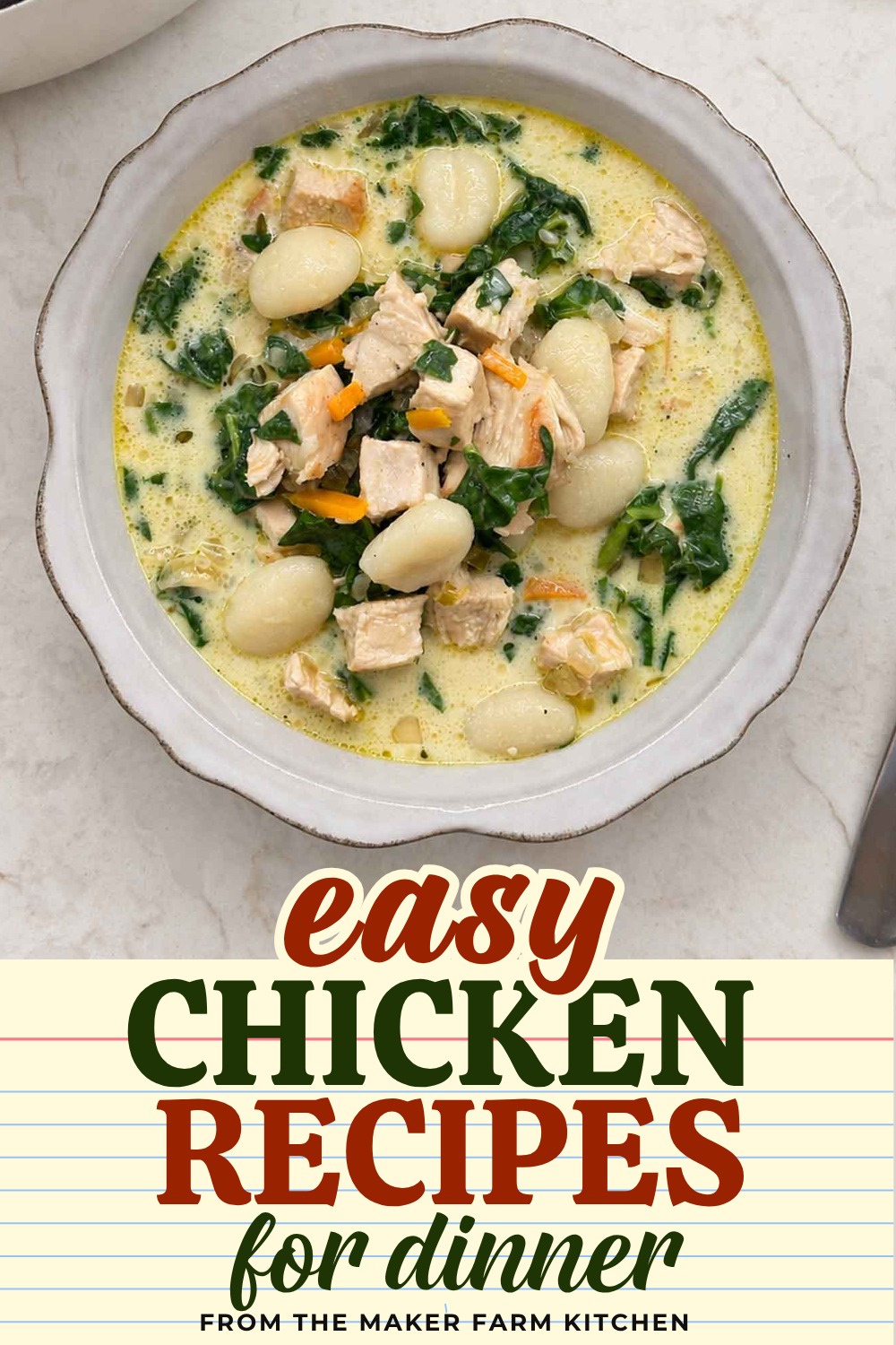 A white bowl of creamy chicken gnocchi soup with spinach, carrots, and potato gnocchi