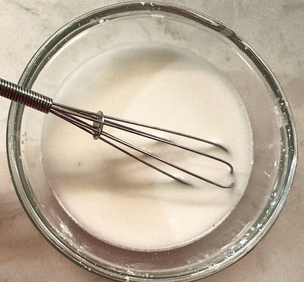 Cornstarch whisked into cold water to make a smooth slurry for thickening the gravy