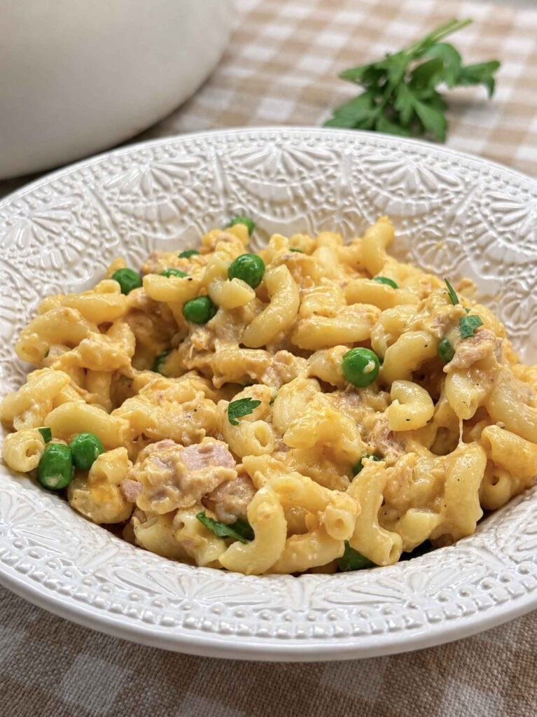 A bowl of cheesy, creamy tuna pasta with peas