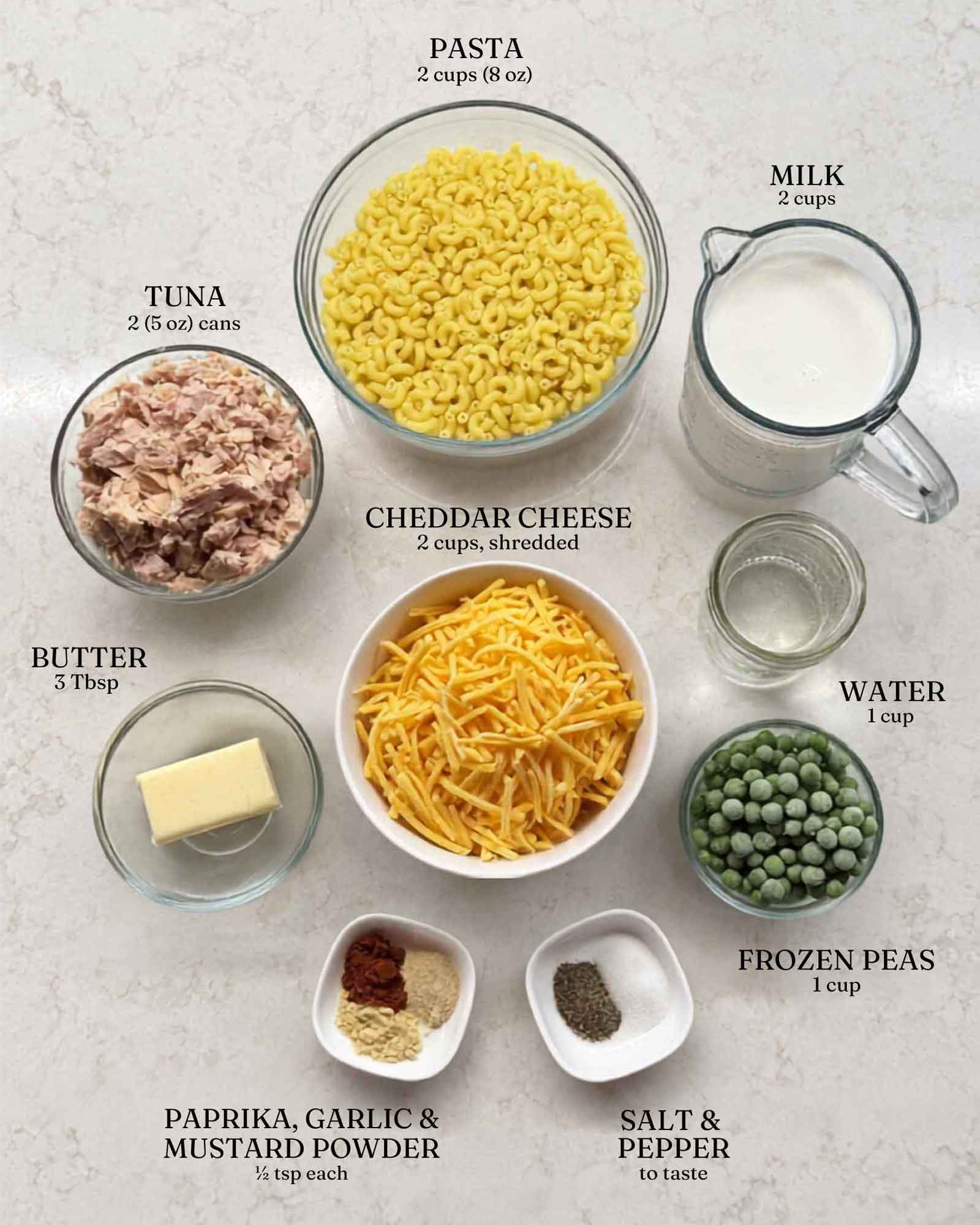 Labeled ingredients for creamy tuna pasta: pasta, tuna, milk, water, butter, cheddar cheese, frozen peas, paprika, garlic powder, mustard powder, salt, and pepper