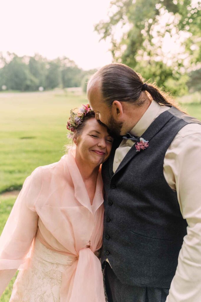 Greg kissing Jennifer's head at wedding