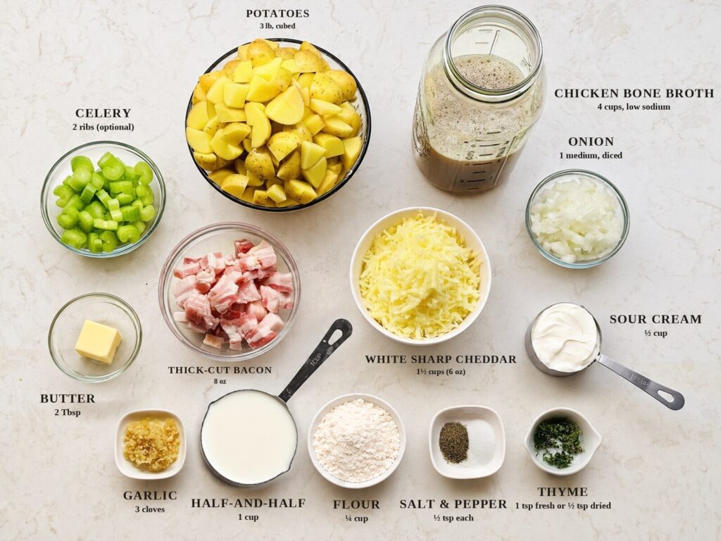 Labeled ingredients for loaded potato soup: cubed Yukon Gold potatoes, chicken bone broth, celery, onion, thick-cut bacon, white sharp cheddar, butter, sour cream, half-and-half, garlic, flour, salt and pepper, and thyme