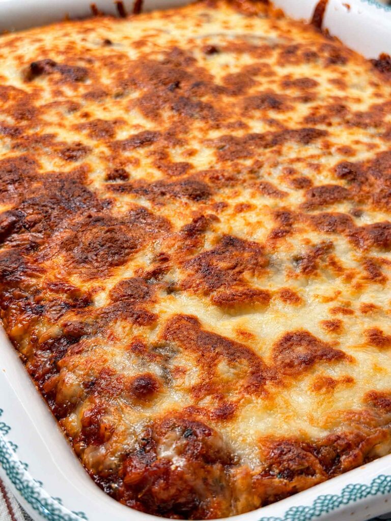 Close-up of the golden, blistered mozzarella top on a pan of baked million dollar spaghetti.