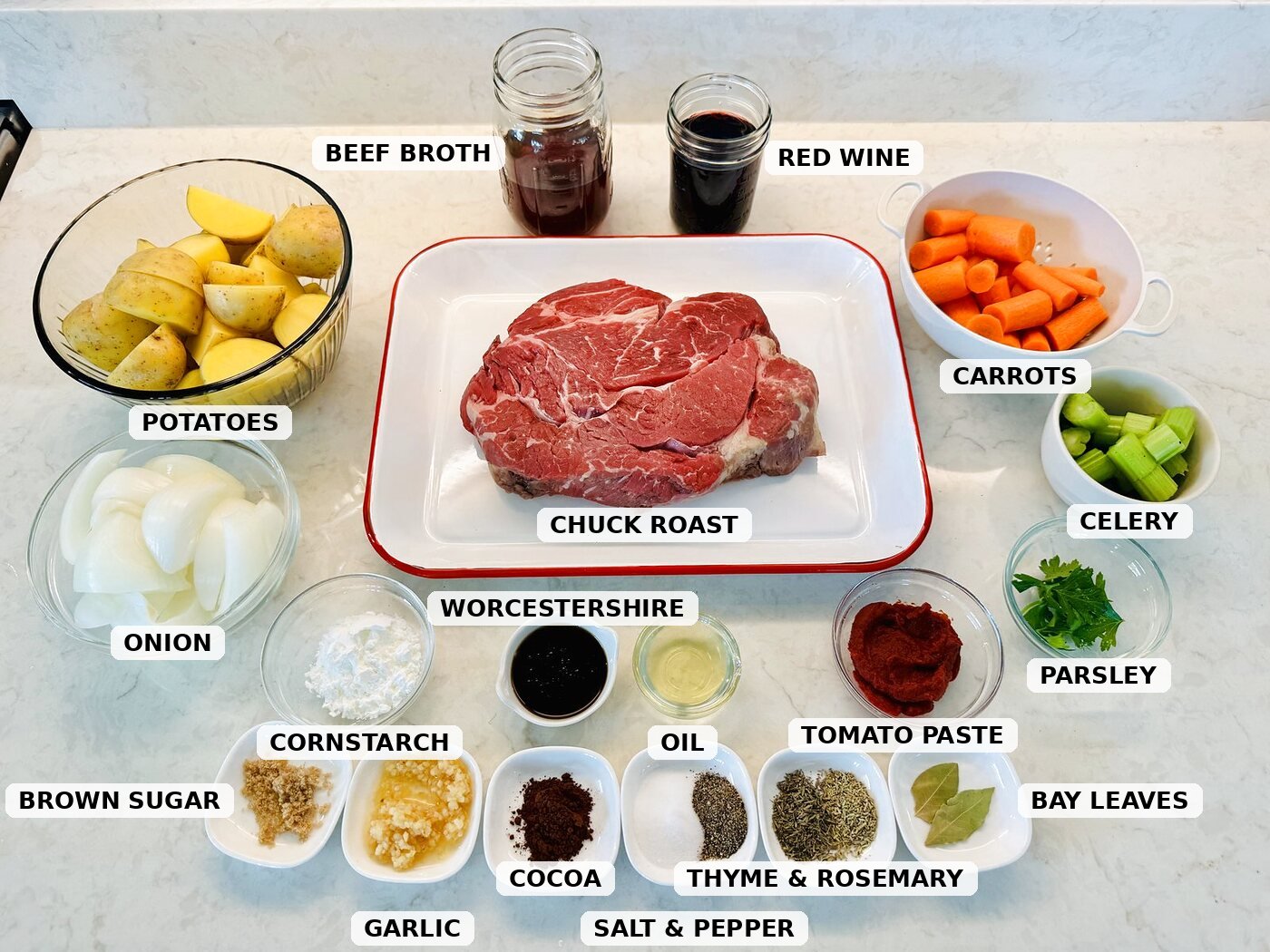 Ingredients for slow cooker pot roast: chuck roast, potatoes, carrots, celery, onion, red wine, beef broth, tomato paste, cocoa powder, and seasonings