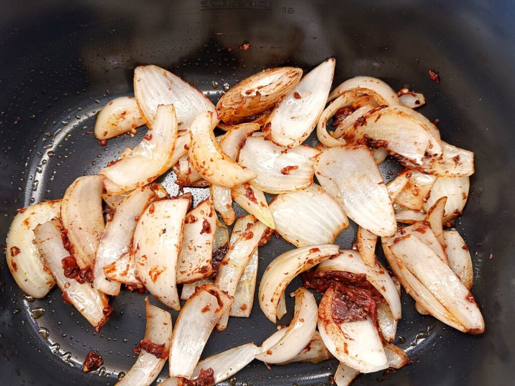 Tomato paste and cocoa toasted into the onions until dark and fragrant