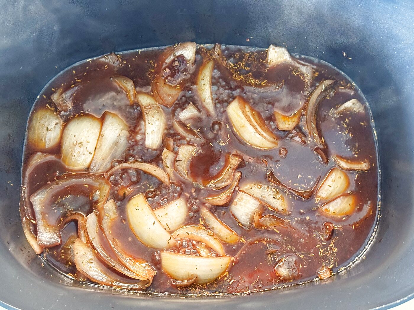 Cabernet and beef broth simmering with onions and herbs after deglazing the pan