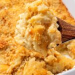 Serving baked mac and cheese with a wooden spoon