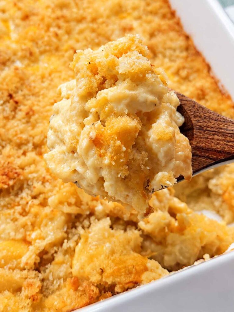 Serving baked mac and cheese with a wooden spoon